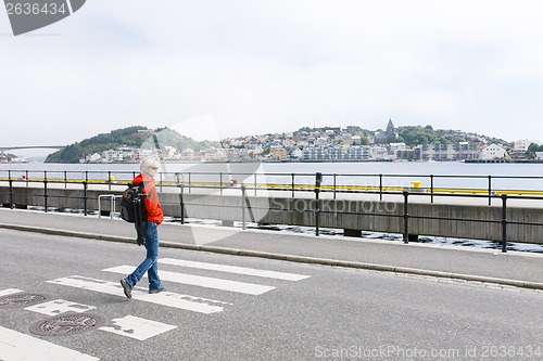 Image of Woman with backpack crossing the street