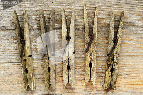 Image of dirty old clothespins on a wooden board