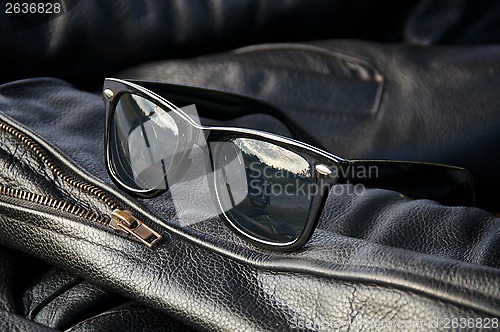 Image of leather jacket detail with sunglasses