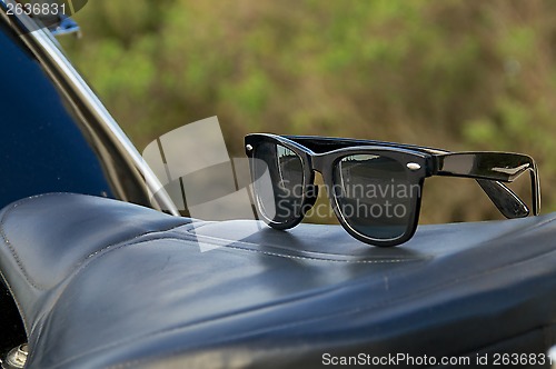 Image of sunglasses on motorcycle saddle