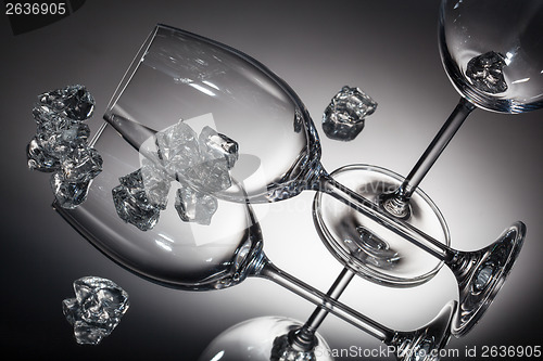 Image of ice and empty wineglasses on color background