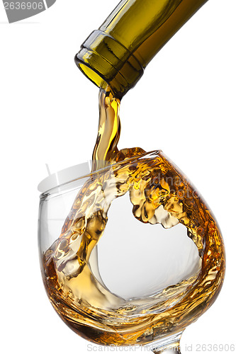 Image of Cognac pouring into glass with splash isolated on white backgrou