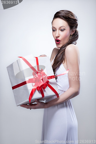 Image of Young smiling woman holding gift