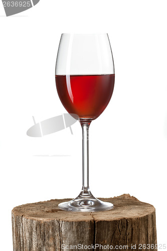 Image of Glass of red wine on stump isolated on white