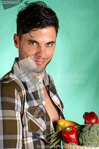 Image of Handsome farmer holding vegetables