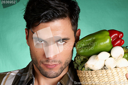 Image of Handsome farmer holding vegetables