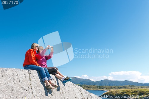 Image of Two women taking photo of Norwegian landscape