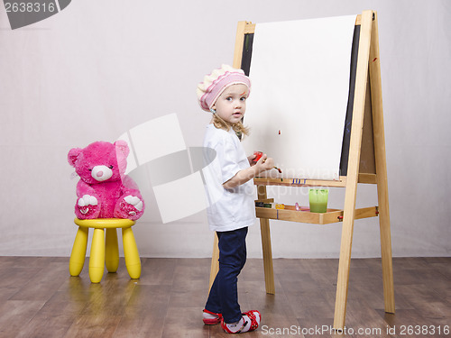 Image of Girl, the artist draws on easel bear