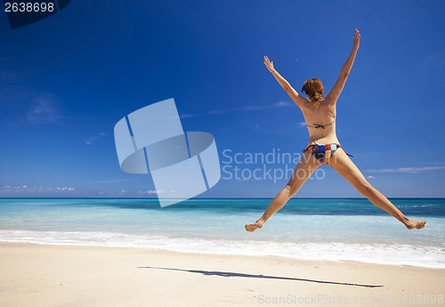 Image of Woman jumping on the beach