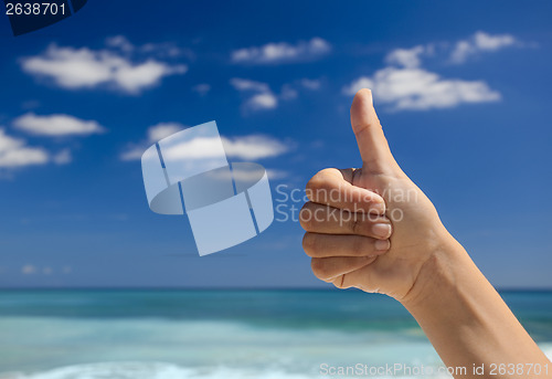 Image of Thumbs up against a blue sky