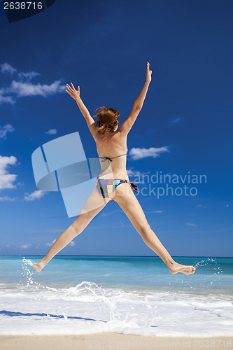 Image of Woman jumping on the beach