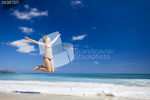 Image of Woman jumping on the beach