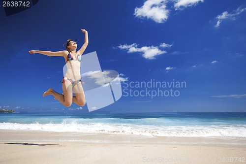 Image of Woman jumping on the beach