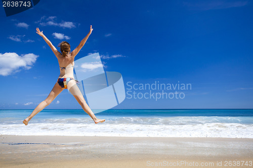 Image of Woman jumping on the beach