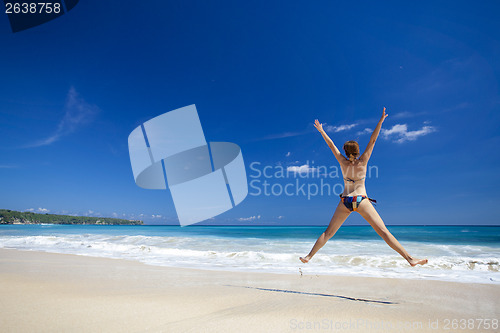 Image of Woman jumping on the beach