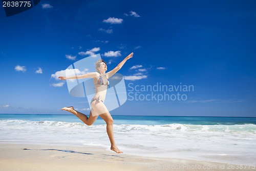 Image of Woman jumping on the beach