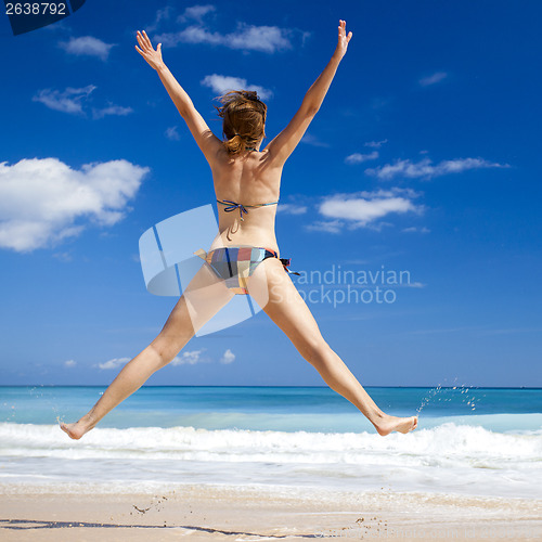 Image of Woman jumping on the beach
