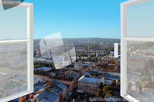 Image of opened window to the roofs of city