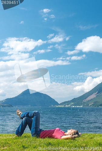 Image of Woman relaxing enjoying at the fjord coast