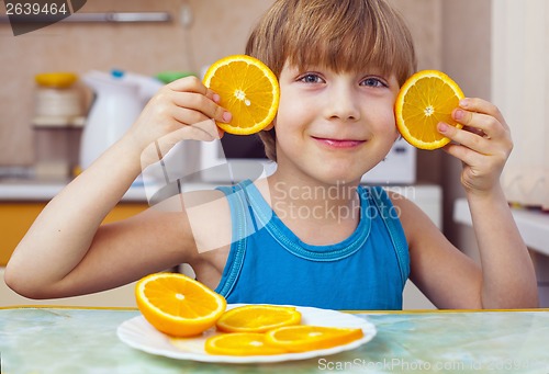 Image of boy eats orange