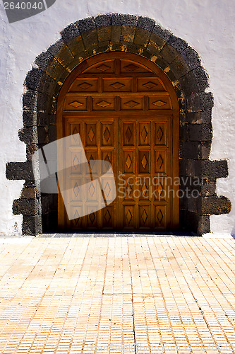 Image of brass brown knocker in a brown closed wood  church door 