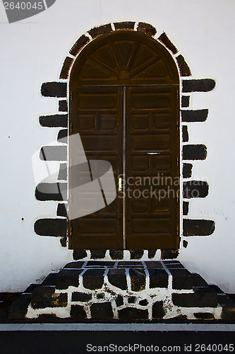 Image of knocker in a brown closed wood  door 