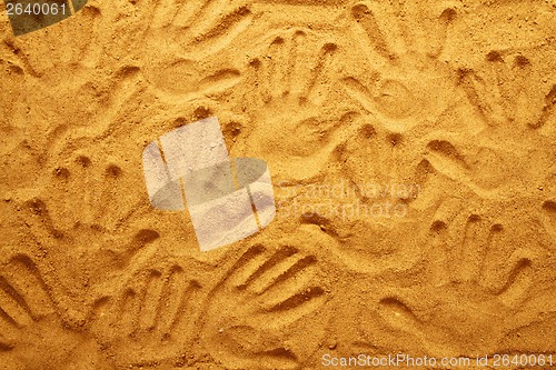 Image of hand prints in the sand