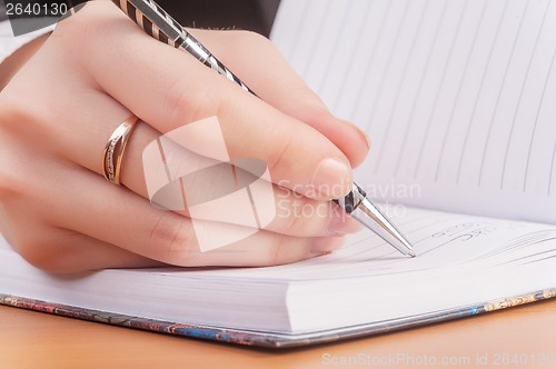 Image of Woman writing in organizer