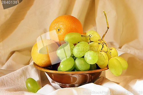 Image of Grape, orange and plum in a vase