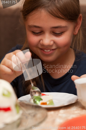 Image of Little girl eating a cake