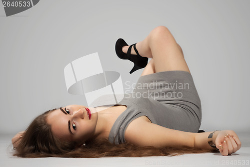 Image of Long-haired teenager girl in gray minis and black high heels