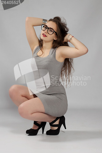 Image of Long-haired teenager girl in gray minis in cool glasses and blac