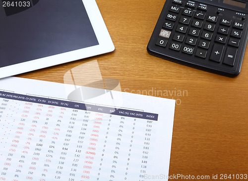 Image of Office table with tablet, calculator and data chart