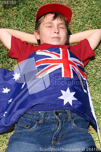 Image of Patriotic boy with flag draped over him