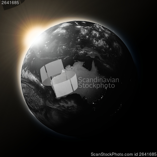Image of Sun over Australia on dark planet Earth