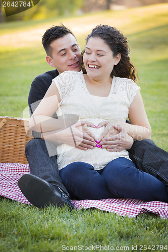 Image of Pregnant Hispanic Couple Making Heart Shape with Hands on Belly