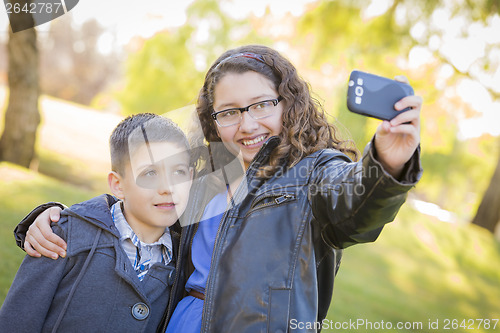 Image of Brother and Sister Taking Cell Phone Picture of Themselves