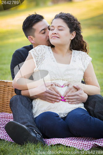 Image of Pregnant Hispanic Couple Making Heart Shape with Hands on Belly