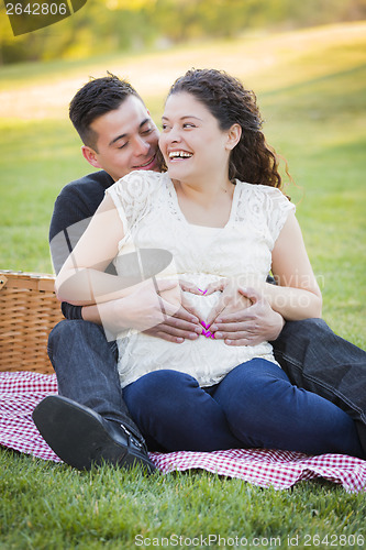 Image of Pregnant Hispanic Couple Making Heart Shape with Hands on Belly