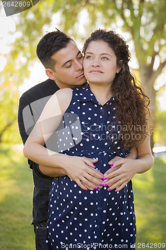 Image of Hispanic Man Hugs His Pregnant Wife Outdoors At the Park