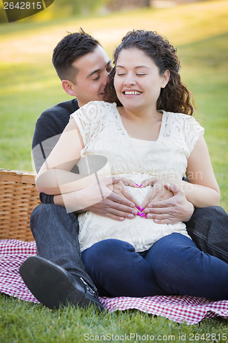 Image of Pregnant Hispanic Couple Making Heart Shape with Hands on Belly