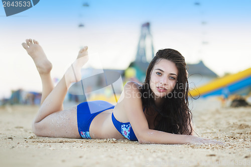 Image of Young brunette posing on the sand