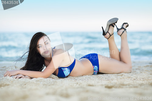 Image of Pretty woman lying on the sand