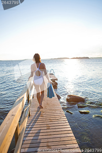 Image of Attractive woman walking on pier