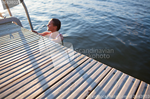 Image of Edge of pier with woman in water