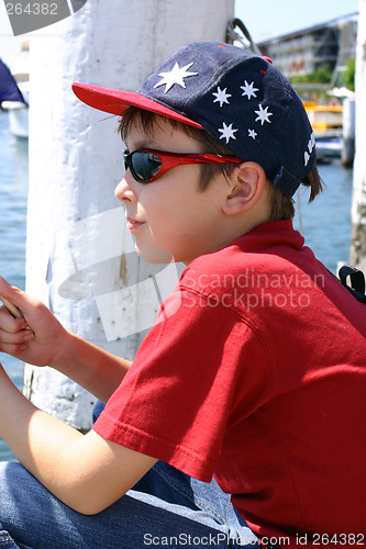 Image of Child sitting on jetty wharf