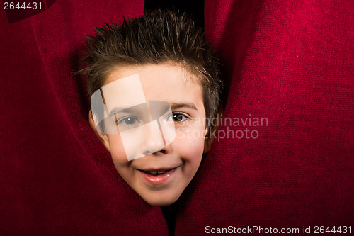 Image of Child appearing beneath the curtain