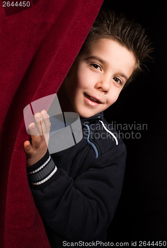 Image of Child appearing beneath the curtain