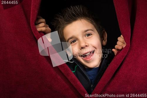 Image of Child appearing beneath the curtain