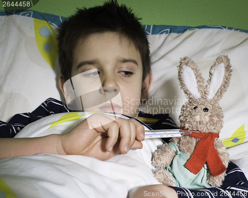 Image of Sick child in bed with teddy bear